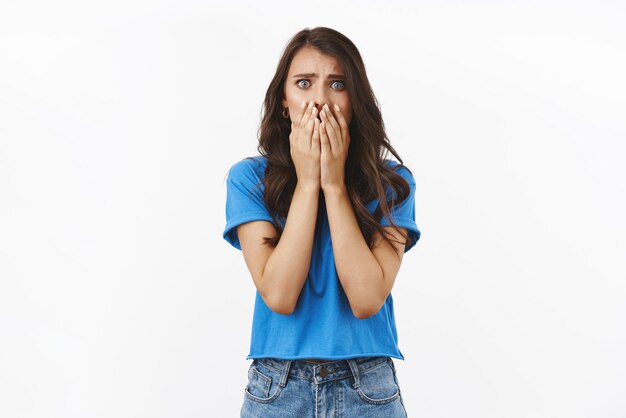 Accident trouble bad situations Shocked and concerned young woman in panic saying oh gosh covering mouth witness terrible crime standing scared and useless over white background