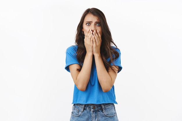 Accident trouble bad situations Shocked and concerned young woman in panic saying oh gosh covering mouth witness terrible crime standing scared and useless over white background