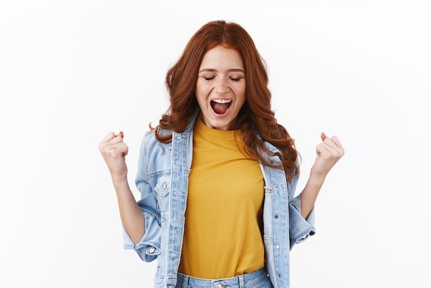 Successo di successo e concetto di celebrazione la ragazza ha finalmente superato tutti gli esami sentirsi sollevata e felice pompare il pugno chiudendo gli occhi e dicendo sì gioendo trionfando su sfondo bianco raggiungere l'obiettivo