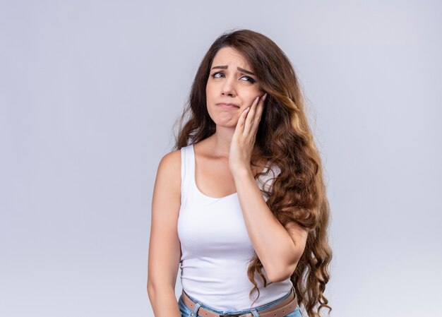 Aching young beautiful girl putting hand on cheek suffering from toothache  with copy space