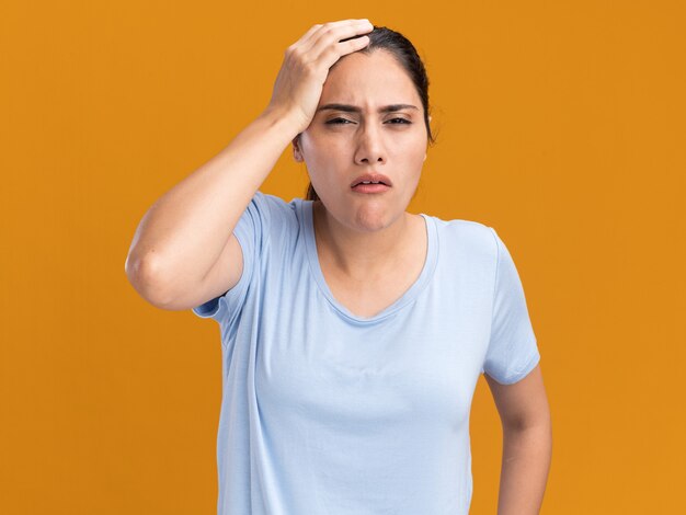 Aching young brunette caucasian girl puts hand on head