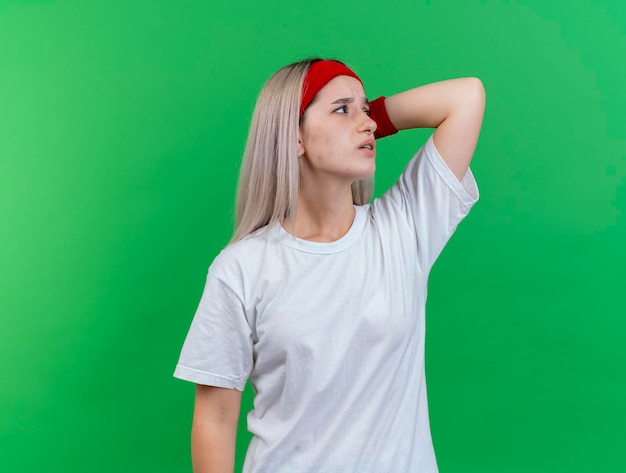 Foto gratuita giovane ragazza sportiva caucasica dolorante con le parentesi graffe che portano la fascia