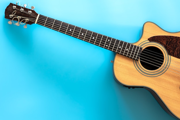 Acoustic guitar on a blue background top view copy space