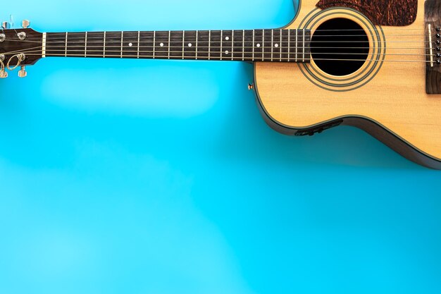 Acoustic guitar on a blue background top view copy space