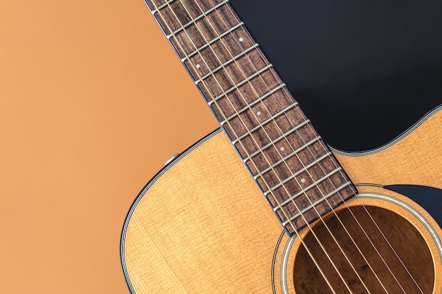 Acoustic guitar closeup on a colored background flat lay