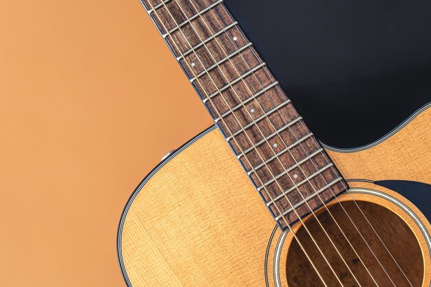 Acoustic guitar closeup on a colored background flat lay