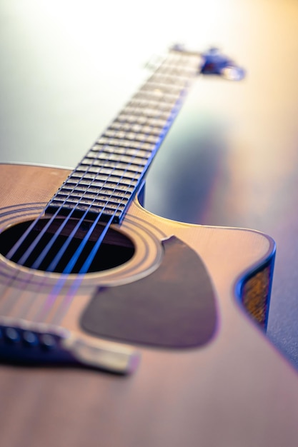 Acoustic guitar music instrument resting against a dark black background