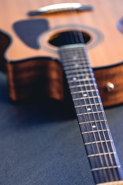 Foto gratuita strumento musicale di chitarra acustica poggiato su uno sfondo nero scuro