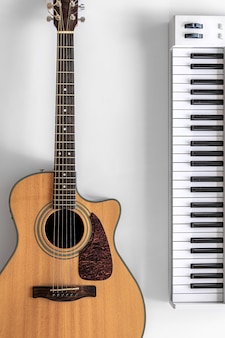 Acoustic guitar and musical keys on a white background flat lay