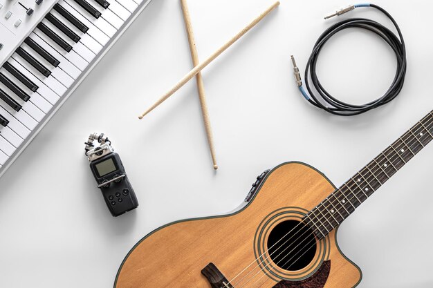 Acoustic guitar and musical keys on a white background flat lay