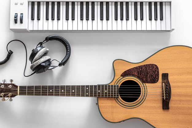 Acoustic guitar and musical keys on a white background flat lay