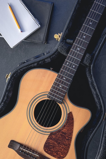 Free photo acoustic guitar and notepad with pencil top view