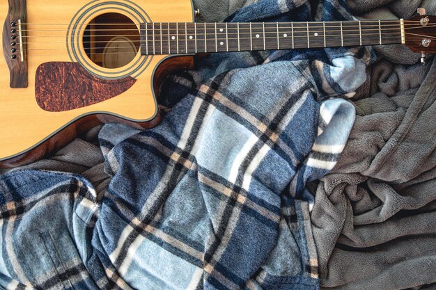 Acoustic guitar on a plaid top view