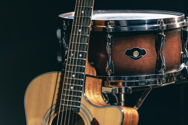 Acoustic guitar and snare drum on a black background isolated