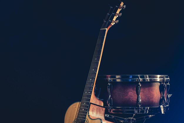 Acoustic guitar and snare drum on a black background isolated