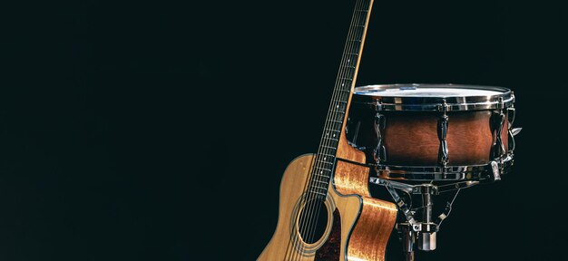 Acoustic guitar and snare drum on a black background isolated