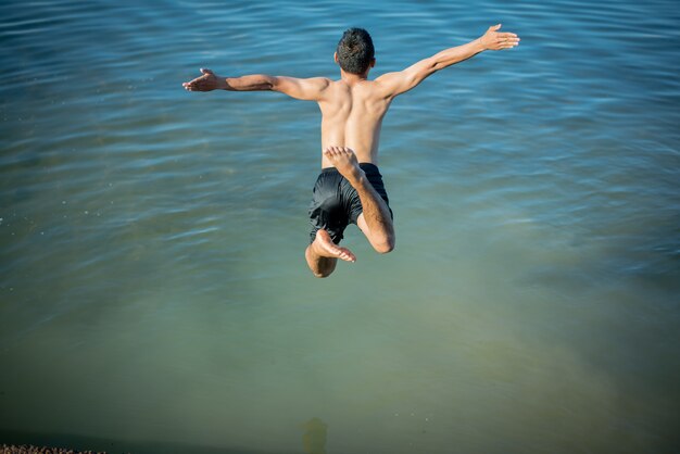 Active Boys Jumping From Logs Into Water.