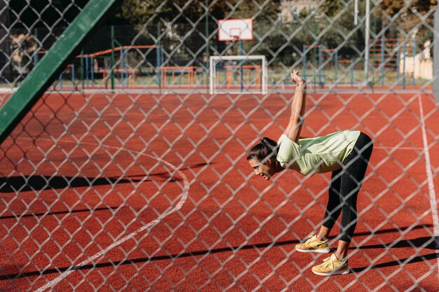 屋外で体を伸ばすスポーツ服のアクティブな女性