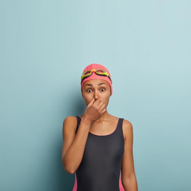 Active female swimmer posing with goggles