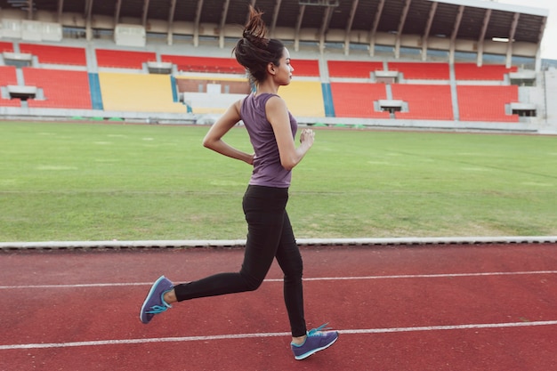 Active girl running in the stadium