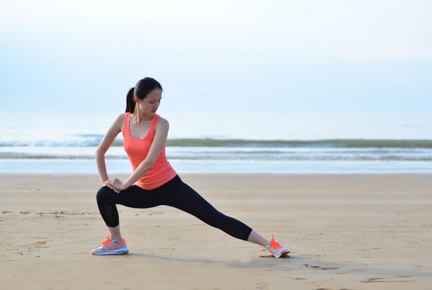 Active girl stretching on the beach