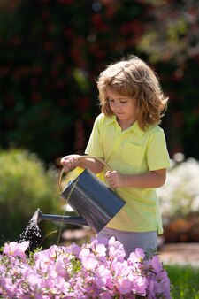 庭​で​ハーブ​や​花​を​育てる​アレント​を​助ける​裏庭​の​子供​に​植物​に​水​を​まく​アクティブな​子供