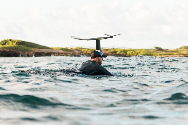 Active man in special equipment staying on a surfing board