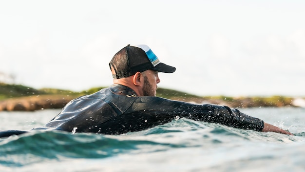 Active man in special equipment staying on a surfing board