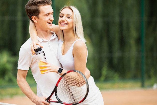 Uomo e donna attivi al campo da tennis