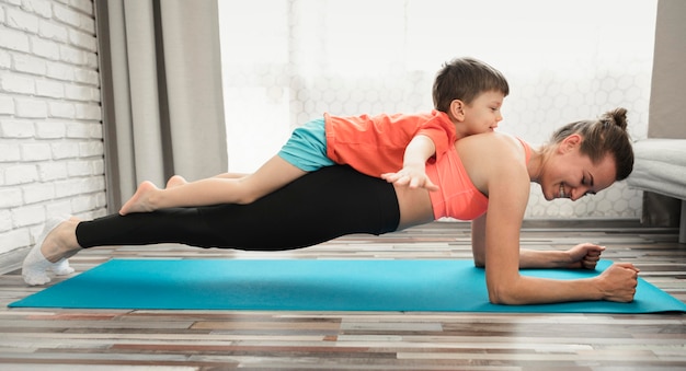 Active mother exercising with little boy