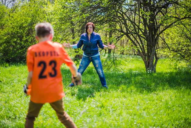 Active mother playing soccer with her son