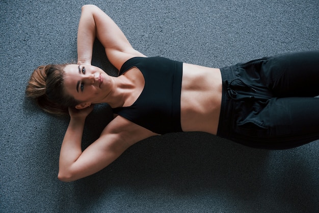 적극적인 훈련. 체육관 바닥에서 복근 운동하기. 아름 다운 여성 피트 니스 여자