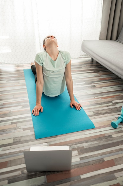 Active woman exercising yoga at home