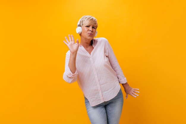 Active woman in headphones sings and listens to music in headphones