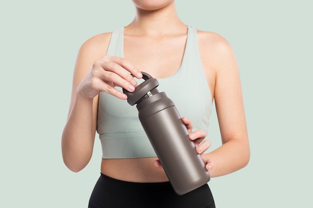 Active woman holding a stainless steel water bottle