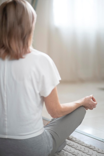 Active Woman In White T Shirt And Grey Leggins Sitting In Yoga Position