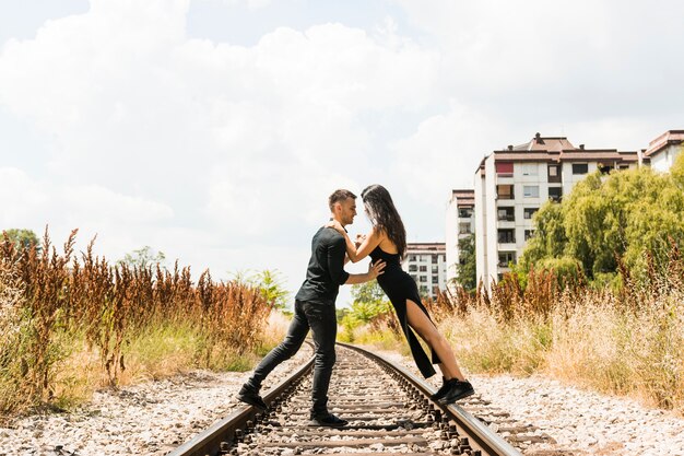 Active young couple dancing on railway track