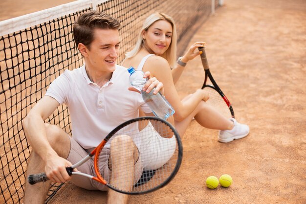 테니스 코트에서 활성 젊은 부부