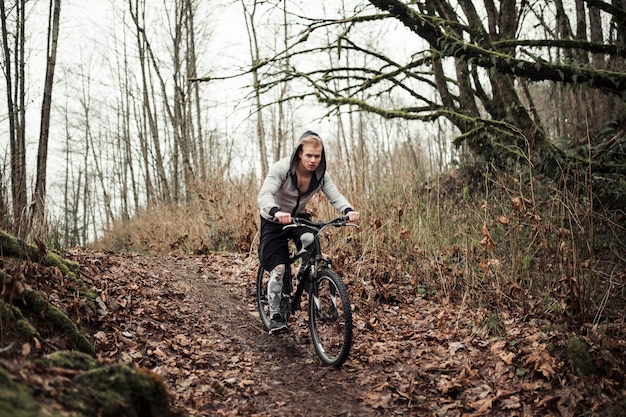 숲에서 활성 젊은이 승마 자전거