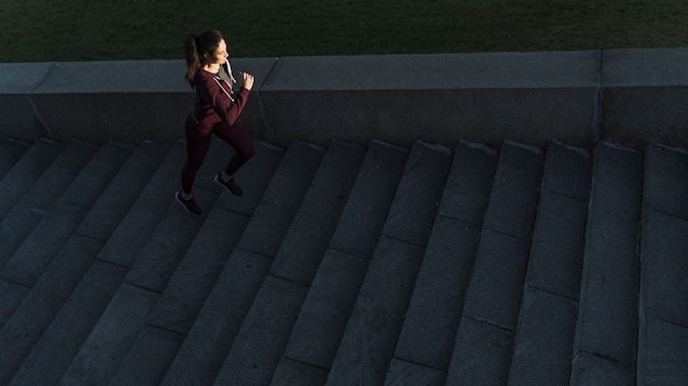 アクティブな若い女性が階段を登る