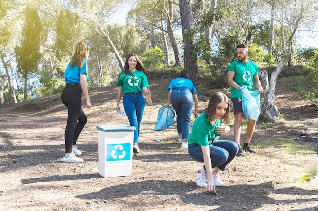 Foto gratuita attivisti che raccolgono spazzatura nel boschetto