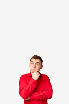 広告の背景。特別なオファー。白いコピースペースのオプションを考慮して孤立した赤いシャツの疑わしい男。
