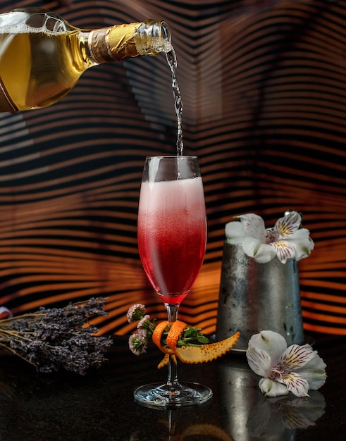 Бесплатное фото Добавляем алкогольный напиток в красный сок с пеной в стакане.