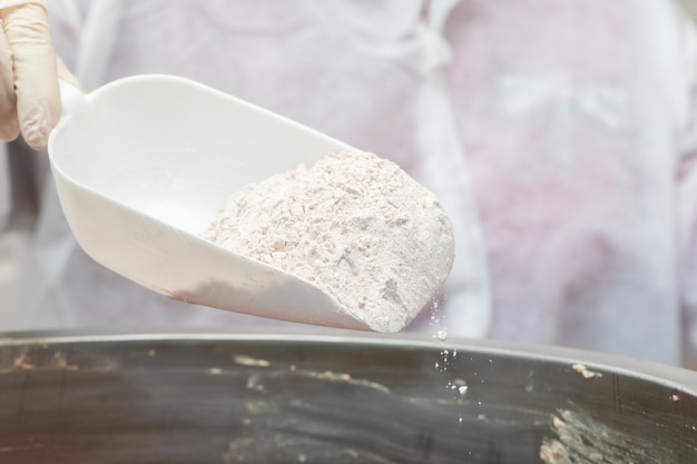 Free photo adding flour into frying metallic pan