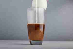 Free photo adding milk to coffee in a glass.