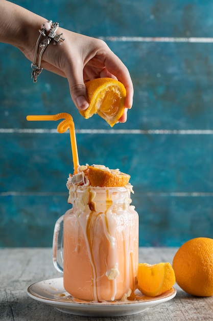 Free photo adding orange juice to milky creamy dessert