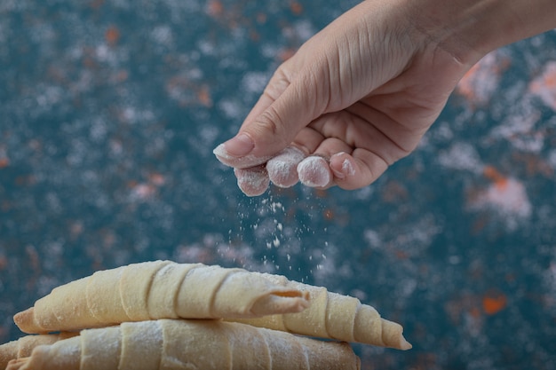 Adding sugar powder on caucasian mutaki cookies.