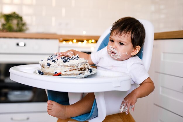 1歳の赤ちゃんの誕生日パーティー赤ちゃんの誕生日ケーキを食べる プレミアム写真