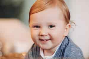 Free photo adorable baby boy smiling at camera. blurred background.