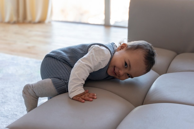 Adorable baby crawling on the couch and smiling